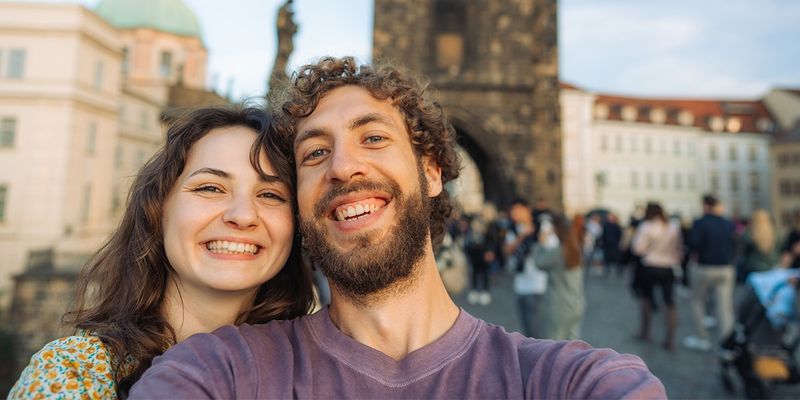 Ett par tar en selfie på Karlsbron i Prag, Tjeckien, och fångar romantiken i en av Europas mest förtrollande stadsresor.