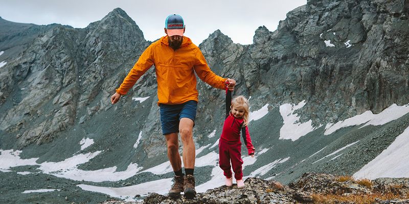 En pappa och dotter går i ett bergslandskap, vilket visar en helbild och olika typer av bildutsnitt inom fotografi hos önskefoto.