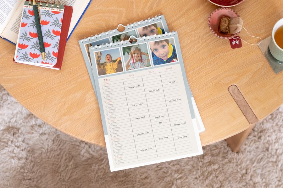 Personlig önskefoto familjekalender visas framträdande på ett soffbord i trä.