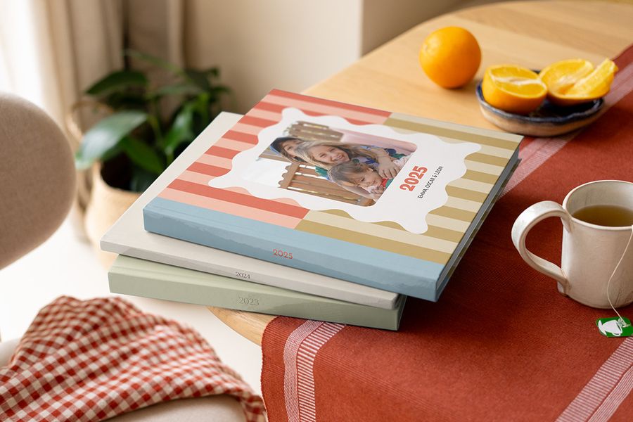 En trave färgglada, mönstrade årsböcker och fotobok årsböcker från Önskefoto med olika design på ett soffbord.