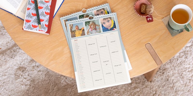 Personlig önskefoto familjekalender visas framträdande på ett soffbord i trä.