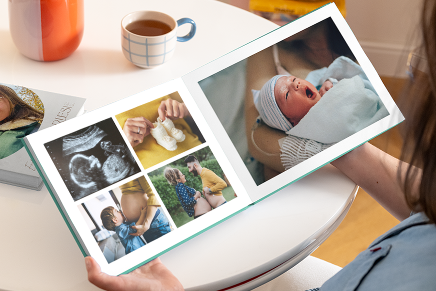 En öppen fotobok mitt första år som visar en gravidmage, ultraljud och tossor på vänster sida och en nyfödd bebis på höger sida.