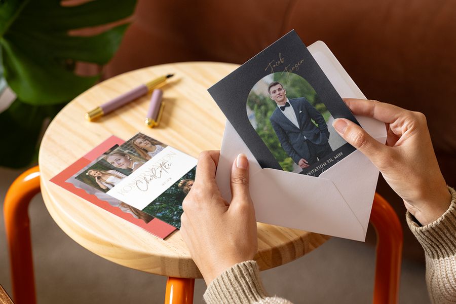 En person som tittar på personliga konfirmationskort och inbjudningar inför en meningsfull konfirmation 2026 med önskefoto.