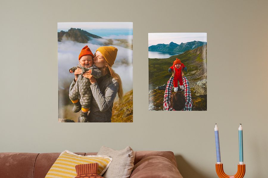 Två familjeposters föreställande mamma och bebis ovanför en soffa, monterade med poster strips för att hänga upp tavlor utan spik med önskefoto.