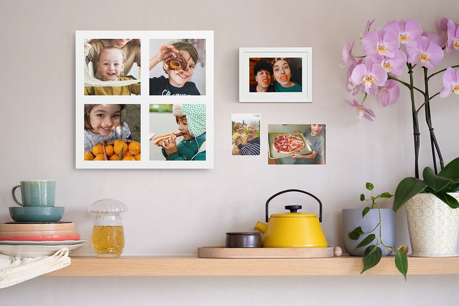 En trähylla med hemtrevlig inredning står under ett personligt fotokollage med barn, ett roligt inramat fotoprint och två familjefoton på väggen, som visar kreativa sätt att använda foton på väggen i hemmet.