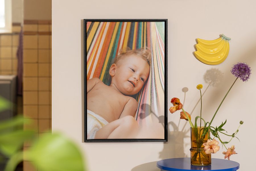 Personlig önskefoto väggkonst med ett foto av en baby bredvid blommor och fruktdekoration, som inspiration till sommardekoration i hemmet.