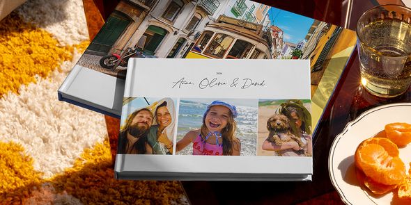 Två olika önskefoto resefotoböcker visas tillsammans, bland annat en liggande fotobok resa med familjens resebilder på omslaget och en annan med en semesterbild av en spårvagn, som inspiration till olika typer av fotoalbum travel.