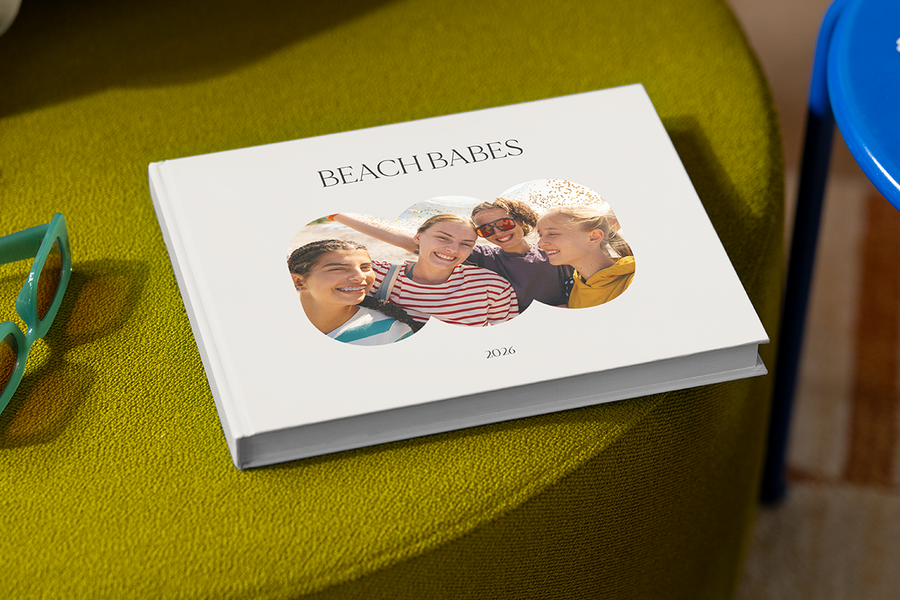 En fotobok med fyra leende tjejer på omslaget heter 'Beach Babes', som illustrerar önskefotos fotobok titel idéer för resor med vänner.