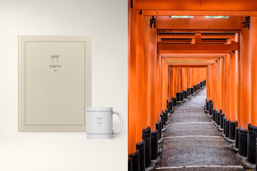En fotobok och mugg med titeln 'Tokyo' står bredvid en bild av orangea helgedomar i Japan, som visar önskefotos Archive Edit-design med rena layouter och subtila omslagsillustrationer.