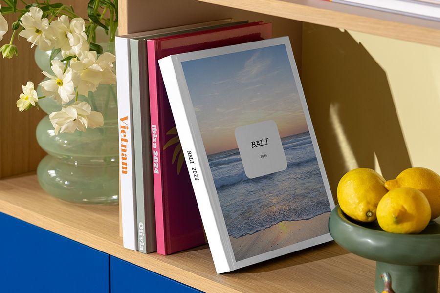 Den nya Modern Travelogue-fotoboken från önskefoto står på en hylla, med rena layouter och elegant typografi inspirerad av resemagasin och soffbordsböcker.