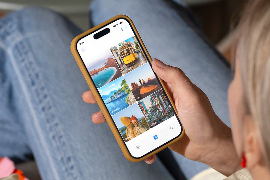 En person tittar på fotomappar i telefonen som är namngivna efter semestermål som 