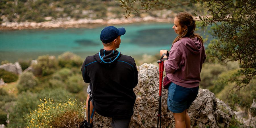 Ett par står i en vacker nationalpark och blickar ut över en blå sjö, vilket fångar den naturliga skönheten i önskefotos guide till Europas vackraste nationalparker.