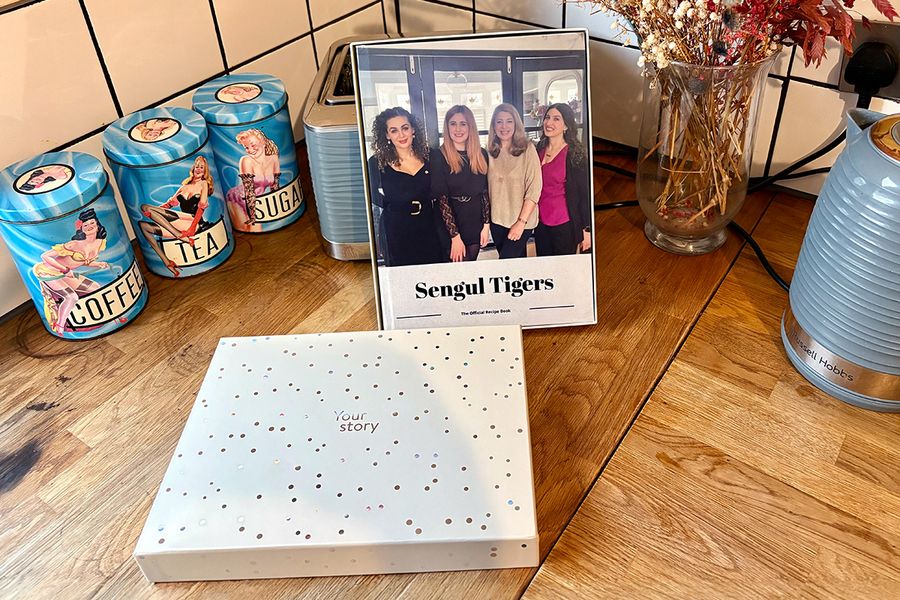 Sarahs personliga familjereceptbok ligger i en önskefoto presentbox, vilket illustrerar hur en personlig kokbok är en omtänksam present till födelsedagar, jubileer och andra speciella tillfällen.