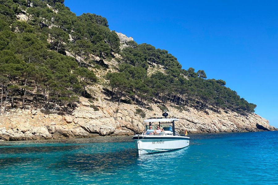 Ett par sitter i en båt vid en vacker, karg kustlinje på Ibiza, vilket fångar den lugnare, avkopplade sidan av en septembersemester på ön.