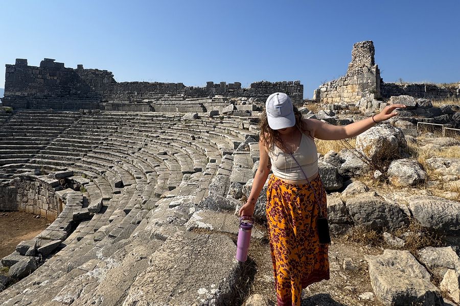 Gemma, copywriter på önskefoto, går bland stenarna vid en amfiteater i Kalkan, Turkiet, vilket illustrerar hur man väljer rätt septemberresmål för semestern.