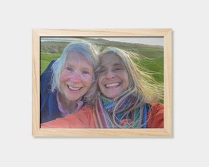 En inramad fotoposter med en bild på två leende kvinnor
