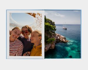 En stor fotobok i stående format med en bild av en person som tittar ut över en fjällsjö