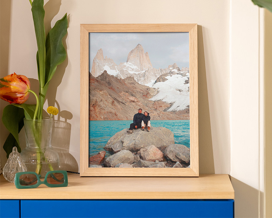 Inramad landskapsbild som lutar mot en trähylla