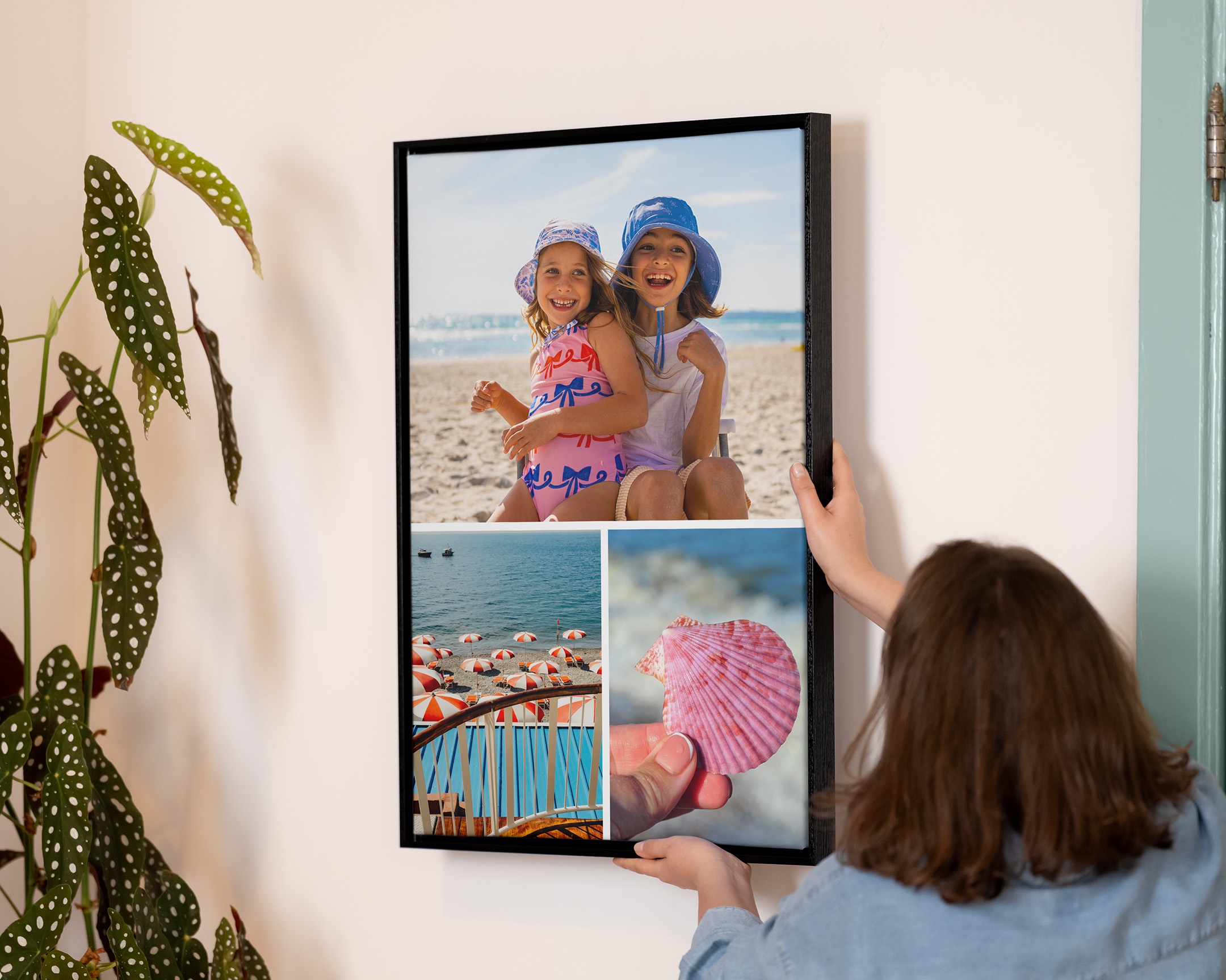 Person som hänger upp ett inramat fotocollage