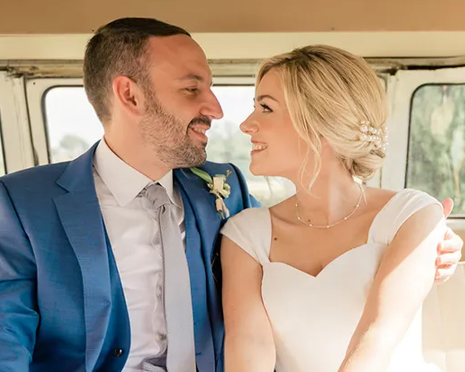 Fee, specialist på redaktionellt innehåll hos önskefoto, och hennes man leende i sin bröllopsbil, vilket illustrerar en personlig berättelse om tips för bröllopsplanering.