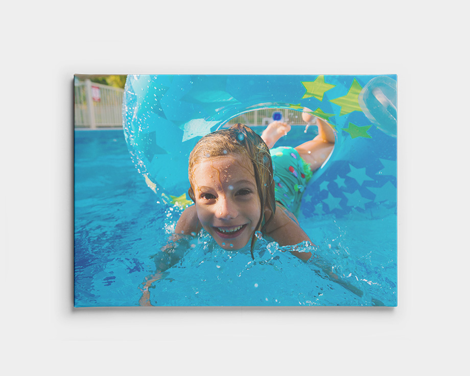 Canvastavla med ett barn som simmar under vattnet i en pool.