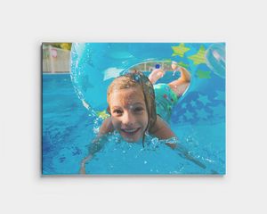 Canvastavla med ett barn som simmar under vattnet i en pool.